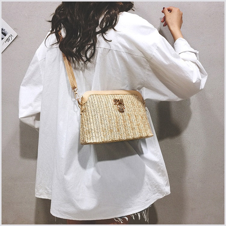 Brown rattan beach bag with a gold chain – worn by a model