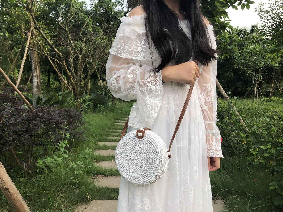 Round boho handwoven rattan handbag – worn by a model