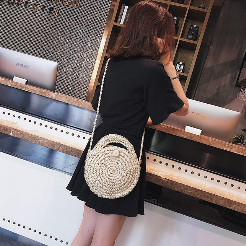 Handwoven straw crossbody bag in natural tones – beige variant, worn by a model