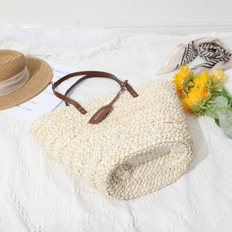 Handwoven straw summer bag with knotted brown handles