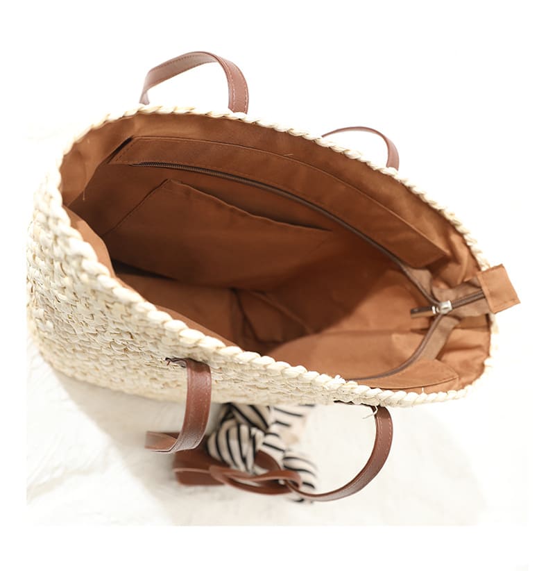 Handwoven straw summer bag with knotted brown handles – close-up detail