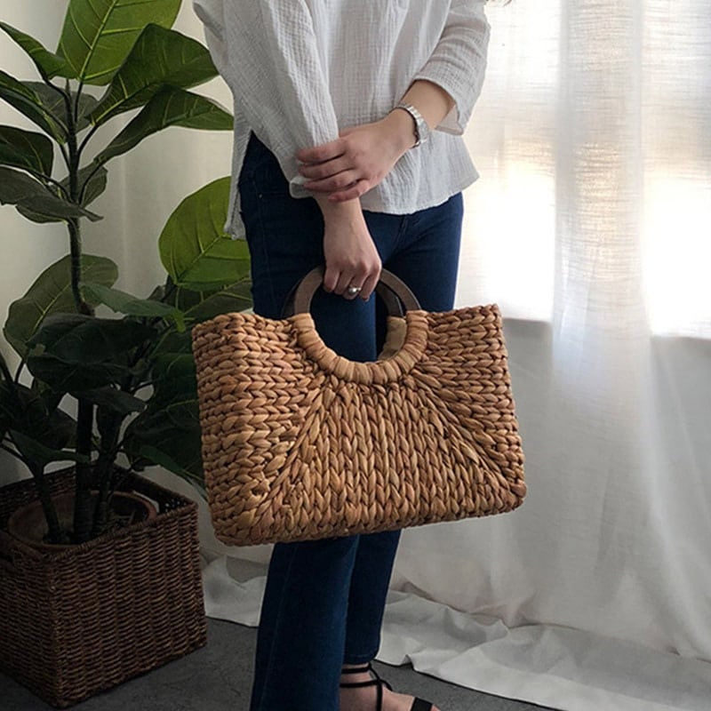 Handmade rattan beach bag with outer pockets – worn by a model (2)