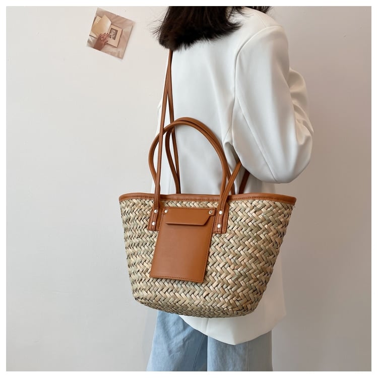 Brown rattan beach tote with a leather handle – worn by a model (2)