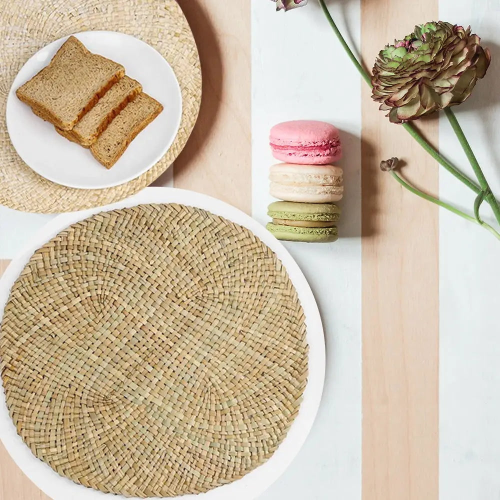 Round handwoven natural straw placemat with a spiral weave – shown in a room setting
