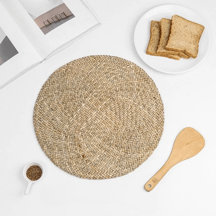 Round handwoven natural straw placemat with a spiral weave – shown in a room setting (2)