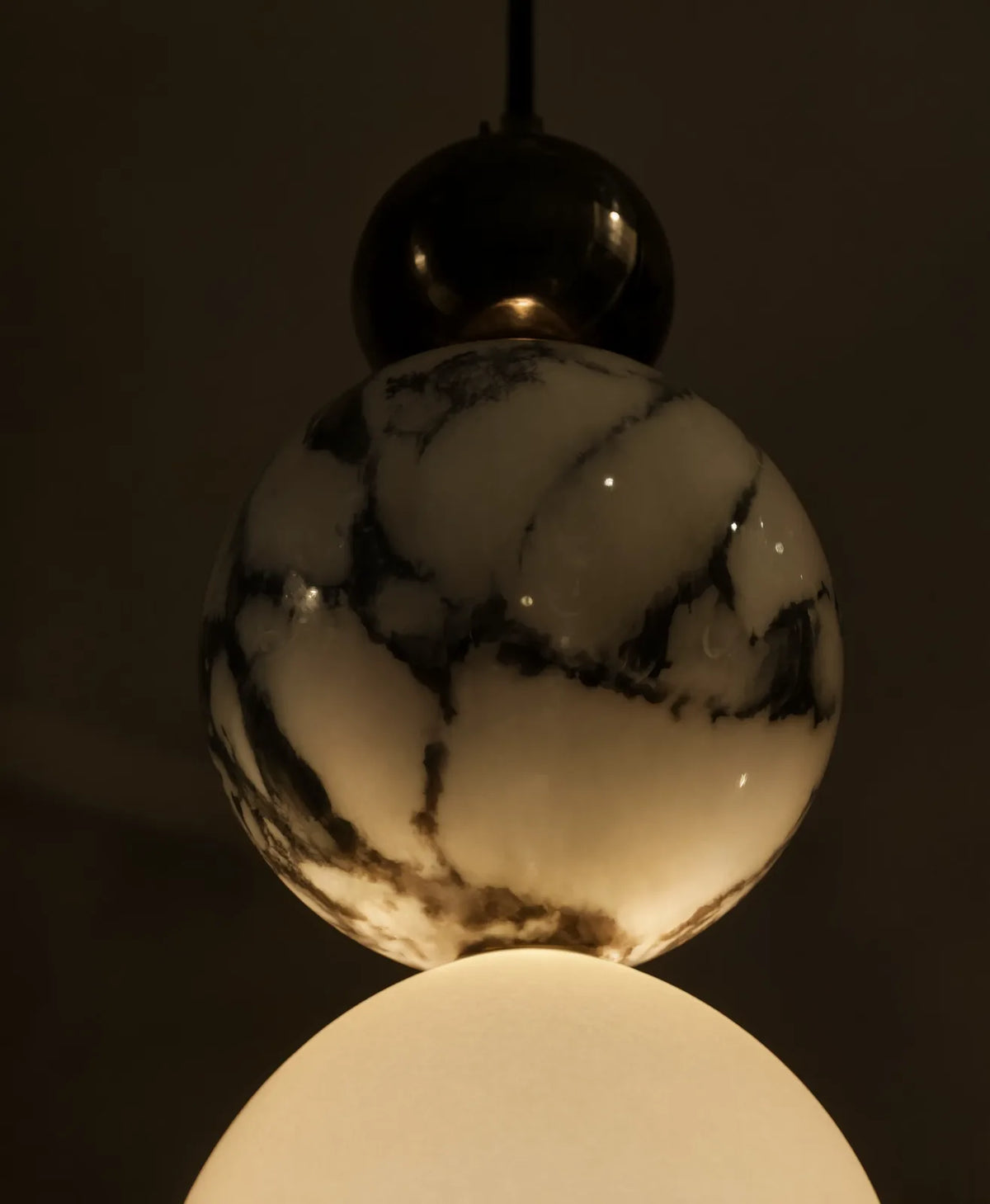 Locres marble and opal glass globe pendant light – close-up detail, lit