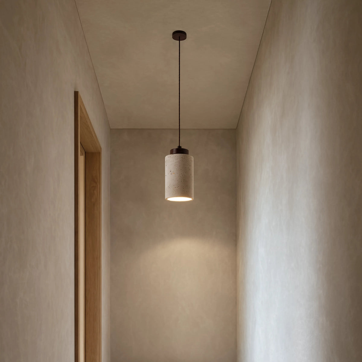 Paestum travertine cylinder pendant light with dark wood cap – shown in a hallway