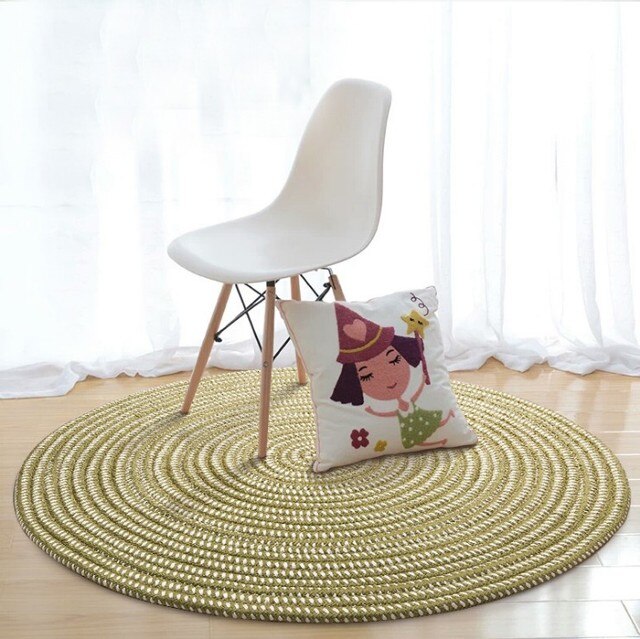 Round green and cream synthetic rattan rug – shown in a room setting