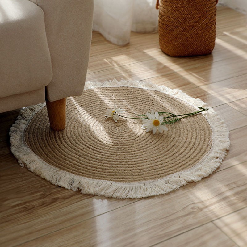 Round handmade cotton and linen rug with a pom-pom fringe – shown in a room setting (2)