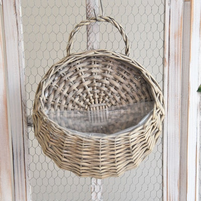 Round hanging rattan wall vase with golden highlights – beige variant, shown in a room setting