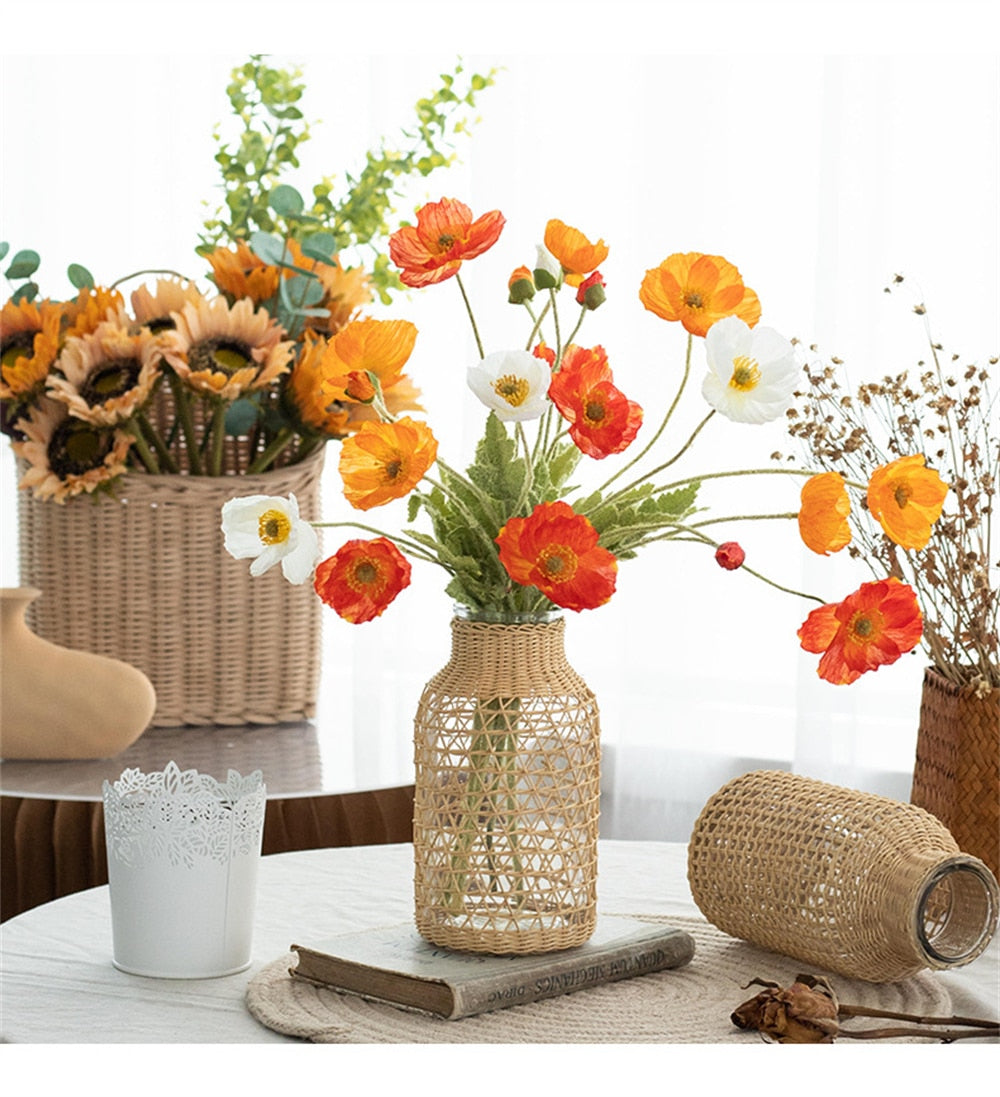 Slender hand-braided rattan vase with a clear glass liner – shown in a room setting