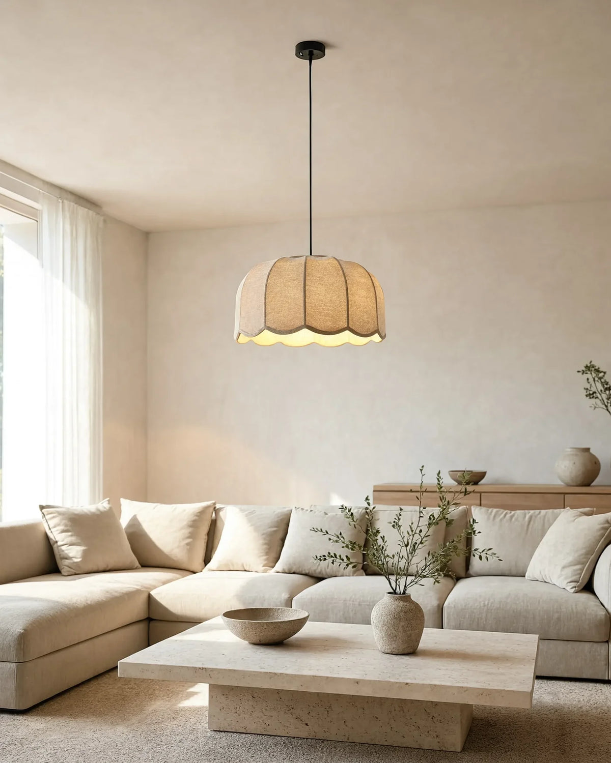 Living room with a scalloped fabric pendant light above a cream sectional