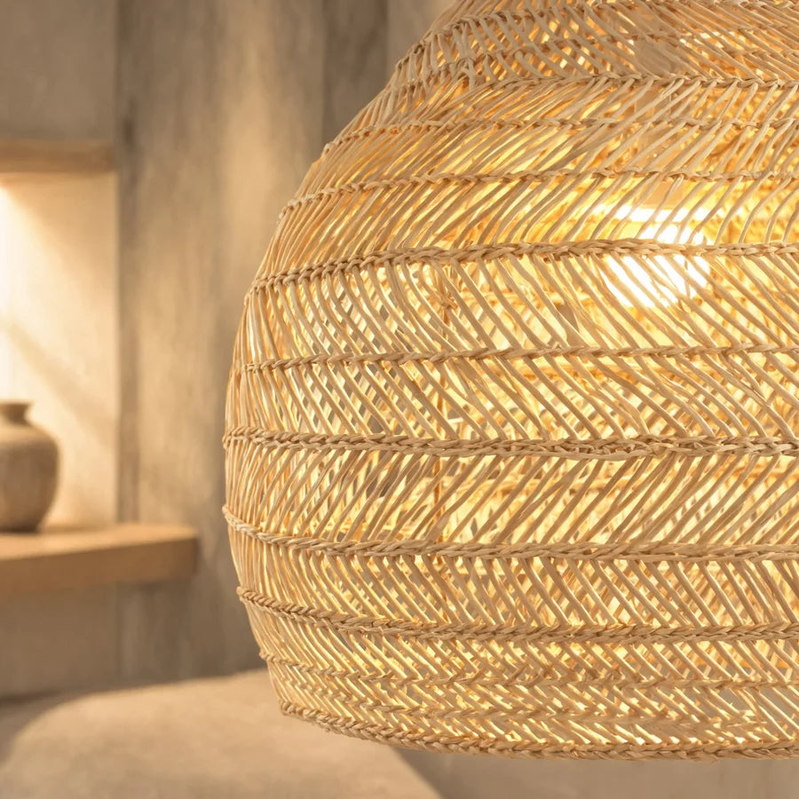 Close-up of a woven rattan pendant shade in warm light