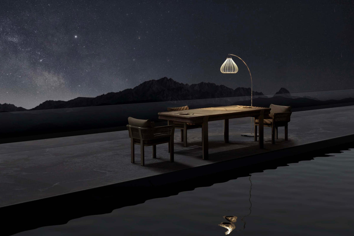 Apollo beige arched solar outdoor floor lamp – shown lit outdoors