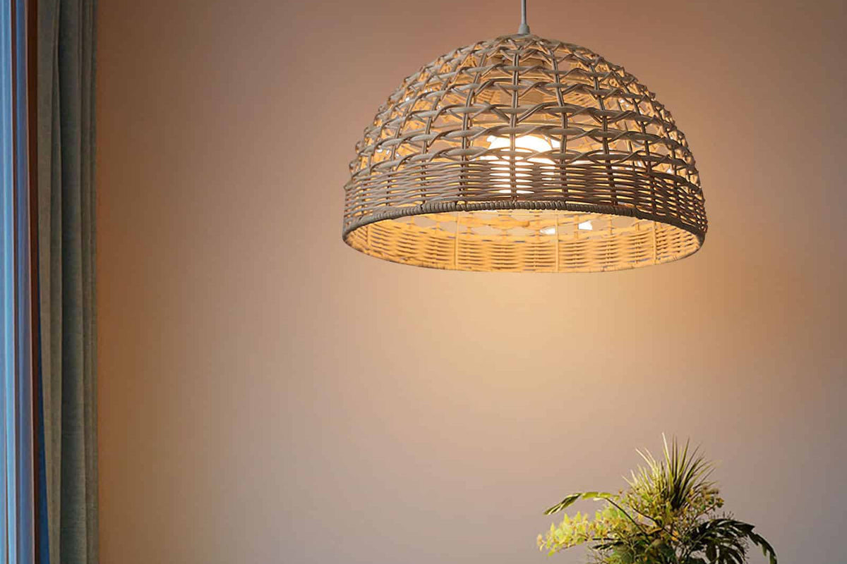 Ovoid handwoven rattan and wicker pendant shade – shown lit in a room setting