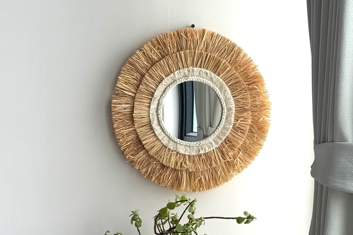 Circular natural straw mirror with an evenly woven frame – shown in a room setting