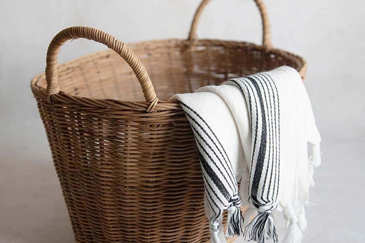 Sturdy vintage rattan laundry basket with a flared, ribbed silhouette – shown in a room setting