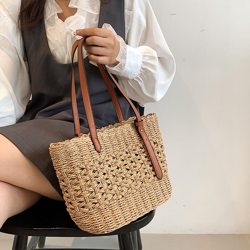 Structured handwoven straw handbag – worn by a model