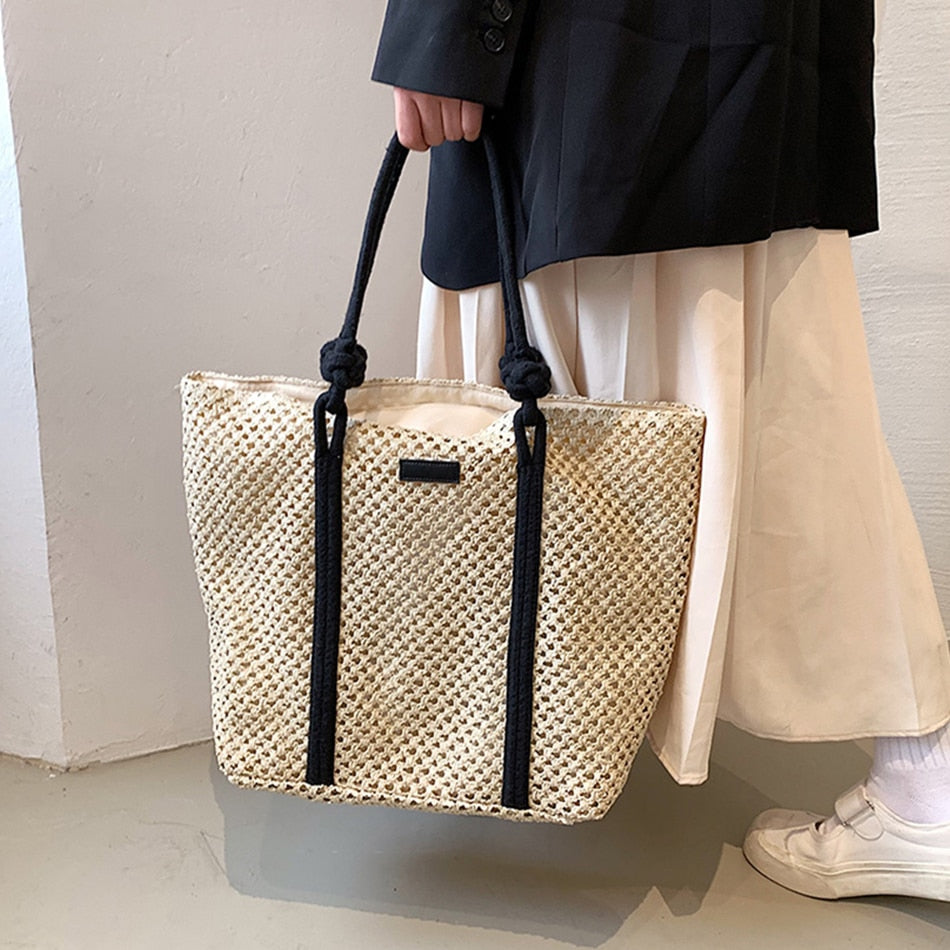 Woven straw handbag with handles – worn by a model