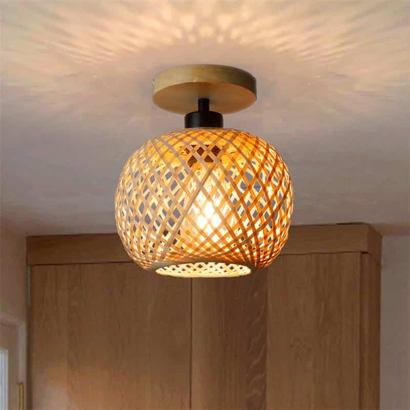 Handwoven rattan ball ceiling light with a tight matte weave – shown lit in a room setting