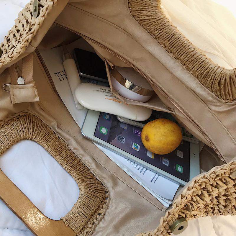 Woven straw tote with varnished wooden handles – close-up detail