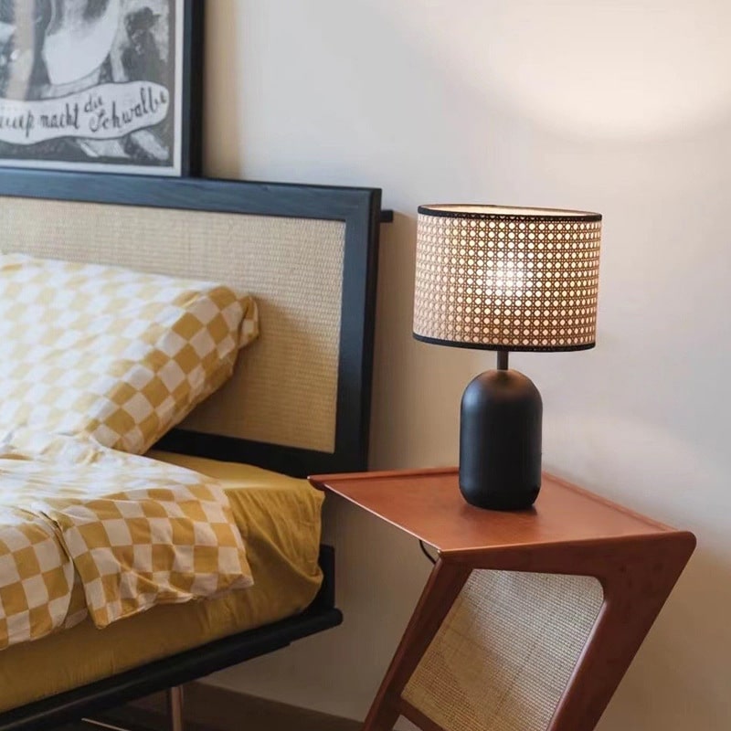 Rattan LED desk lamp with a handwoven shade and black metal base – shown in a room setting (2)