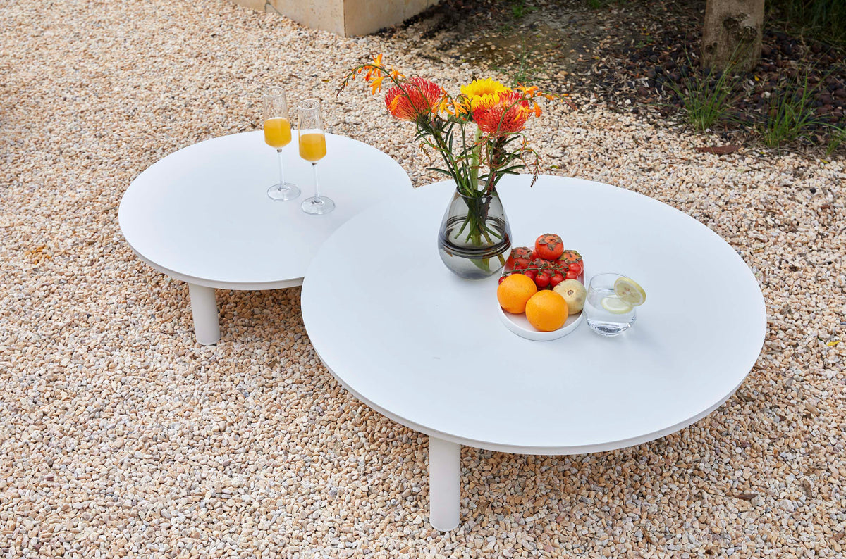 Coffee table from the Ambre white aluminum sofa set with light gray cushions – shown outdoors