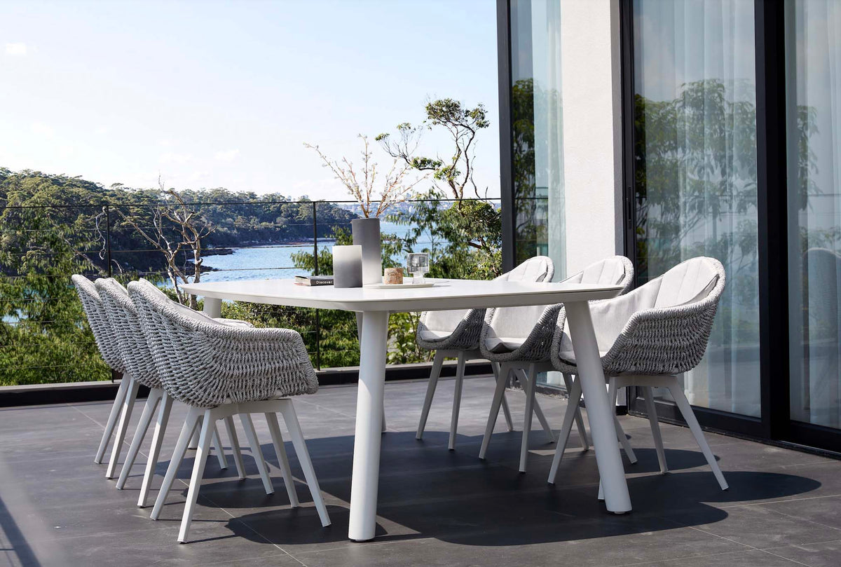 Lara rounded-corner ceramic and white aluminum outdoor dining table – shown outdoors (3)