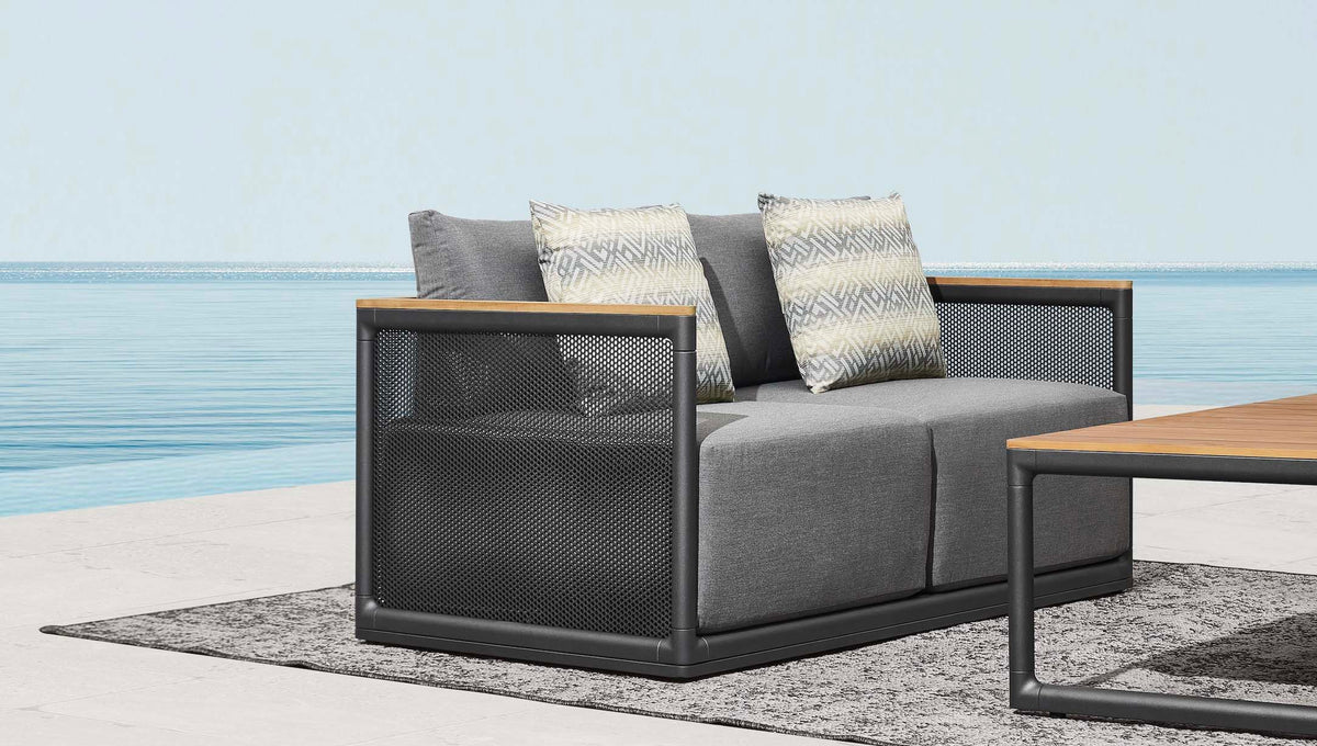 2-seat sofa from the Rio 4-seat aluminum and teak lounge set with open-weave backs – shown outdoors