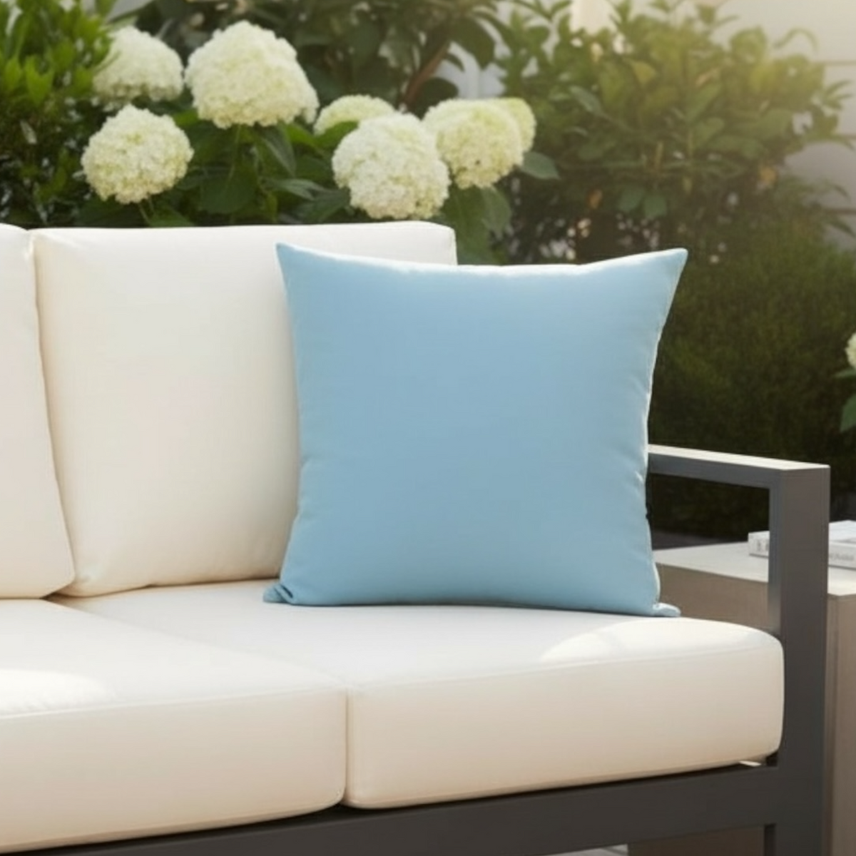 Genius pastel blue Sunbrella outdoor pillow – shown outdoors