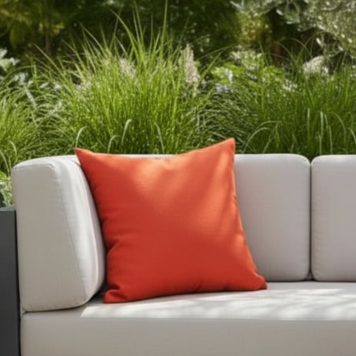 Genius paprika Sunbrella outdoor pillow – shown outdoors