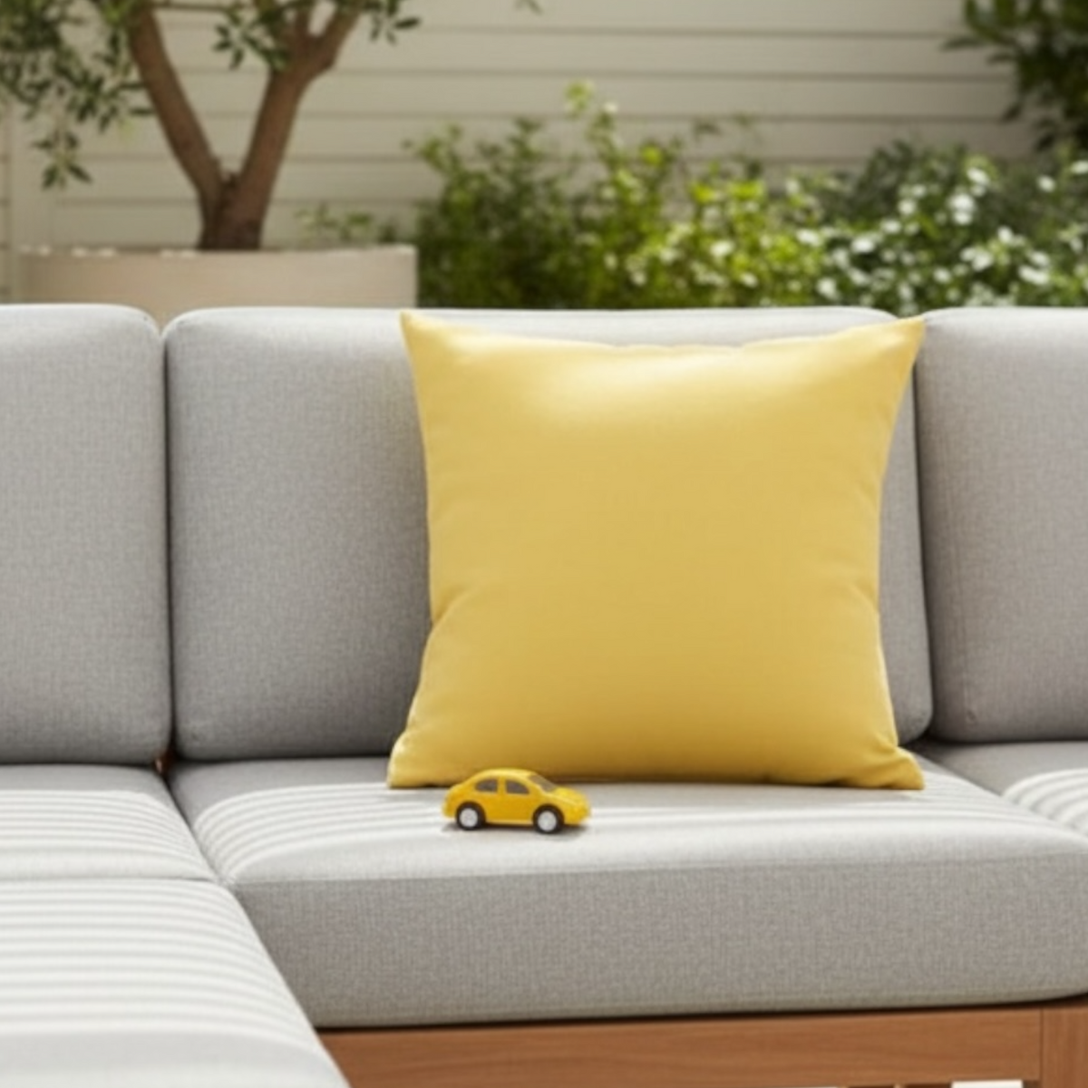 Genius yellow Sunbrella outdoor pillow – shown outdoors