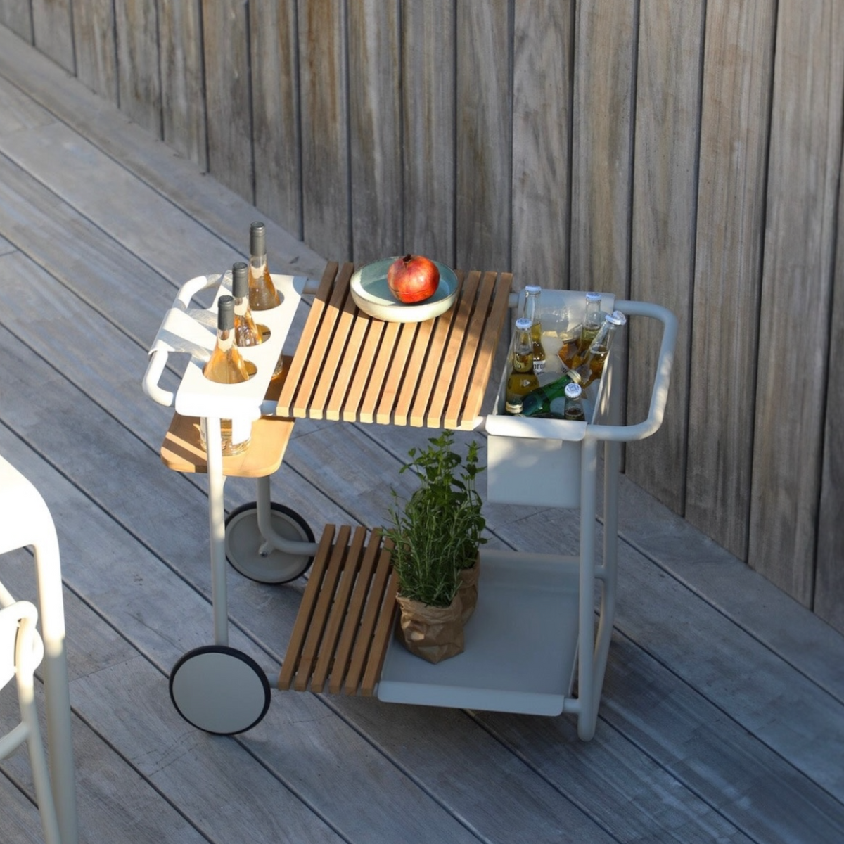 Sunny beige aluminum outdoor bar cart with cooler and teak trays – shown outdoors