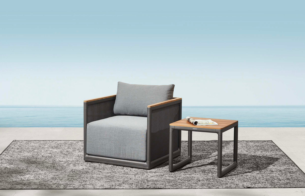 Armchair from the Rio 5-seat aluminum and teak lounge set with large teak coffee table – shown outdoors