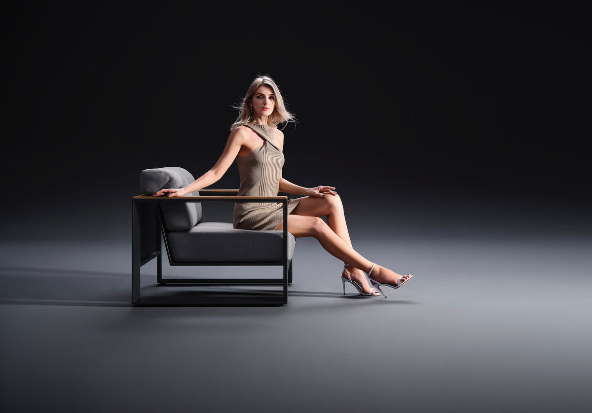 Armchair from the Sofy anthracite aluminum and teak sofa set with solid teak armrests – shown in use