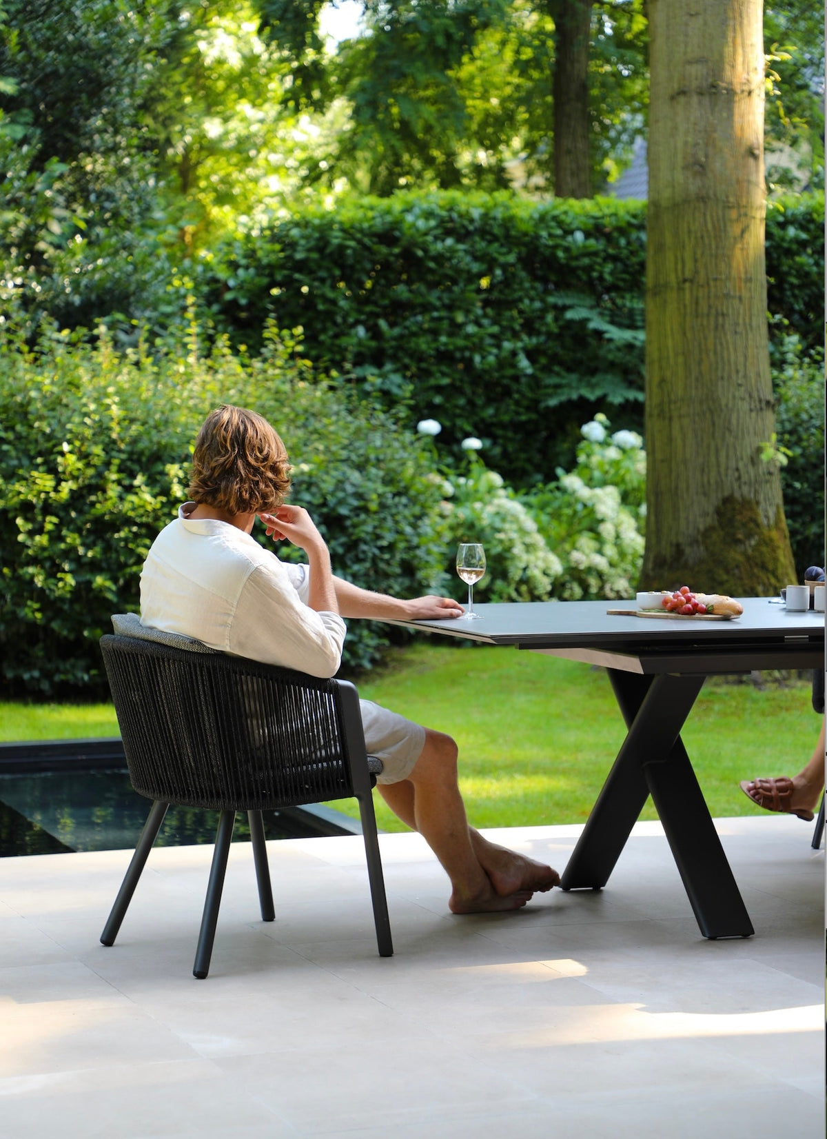 Livio ceramic-top aluminum outdoor dining table with sliding extension – shown outdoors (7)
