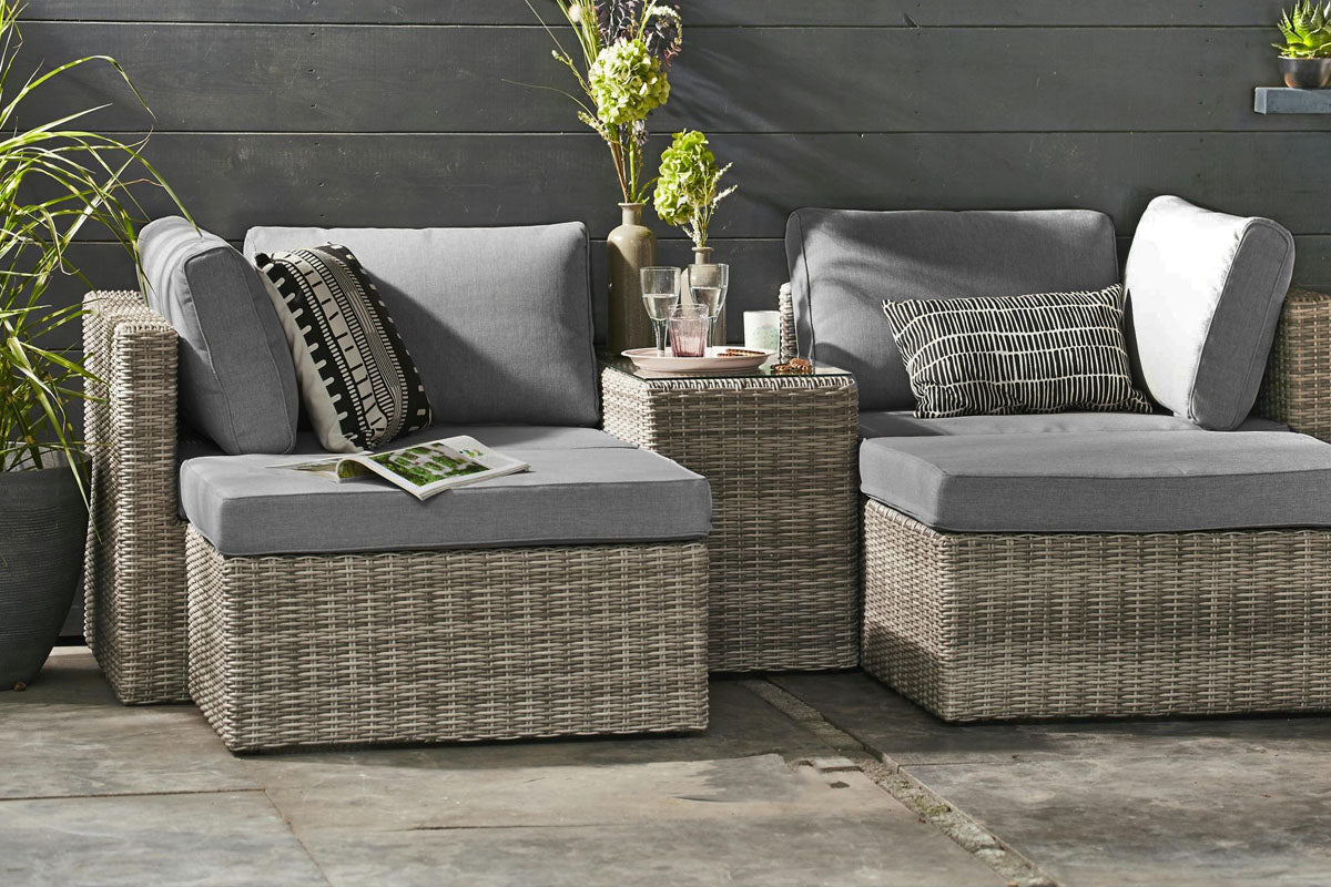 Jade convertible resin wicker sectional in dark gray gradient with poufs – shown outdoors