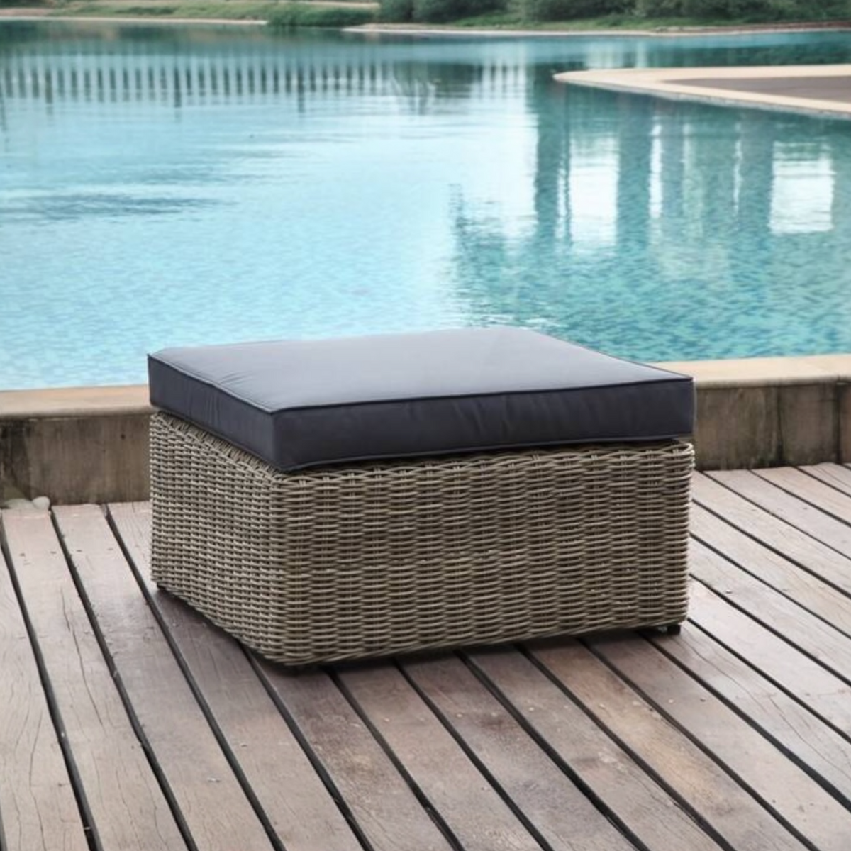 Liberty round resin wicker outdoor ottoman – shown outdoors