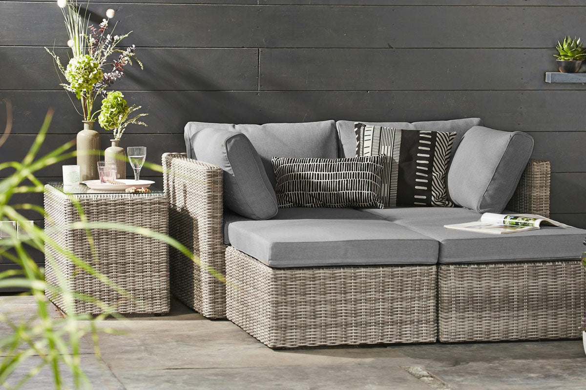Jade convertible resin wicker sectional in dark gray gradient with poufs – shown outdoors (2)