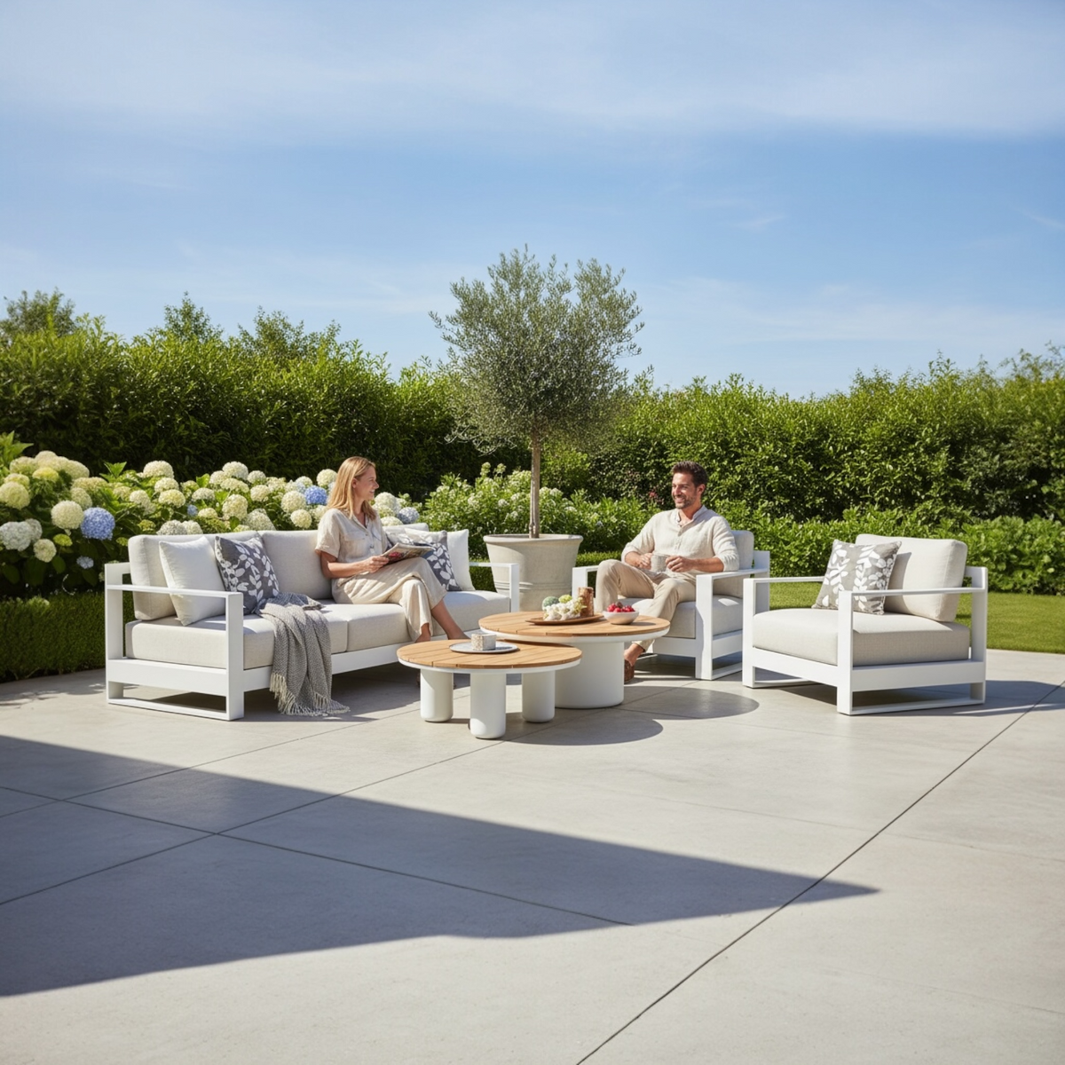 Iris Bis white modular aluminum patio set with light cushions and two coffee tables – shown outdoors (3)