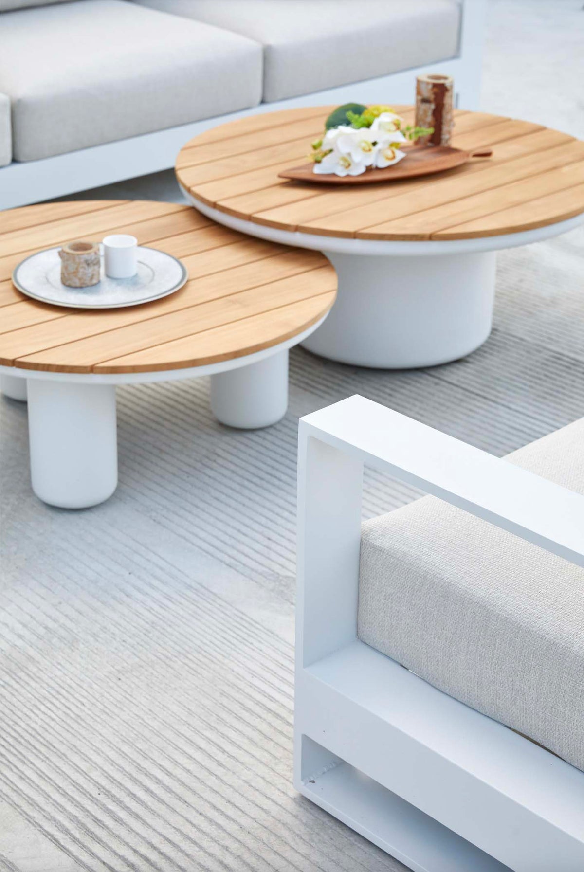 Iris Bis white modular aluminum patio set with light cushions and two coffee tables – shown outdoors (5)