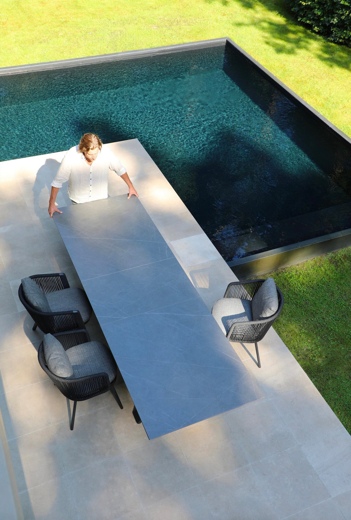 Livio ceramic-top aluminum outdoor dining table with sliding extension – shown outdoors (2)