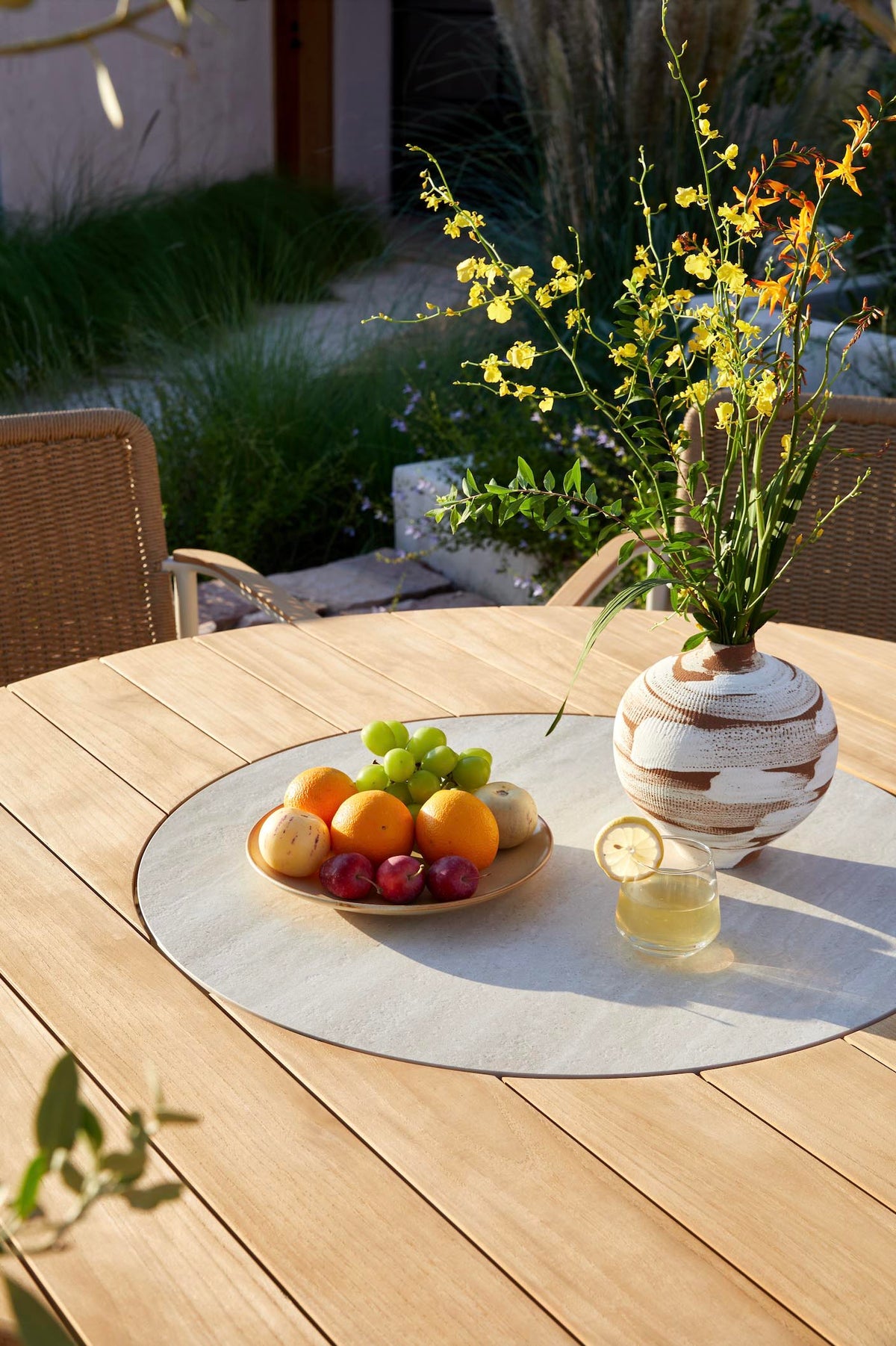 Ariel round teak outdoor dining table with rotating ceramic center – shown outdoors (6)