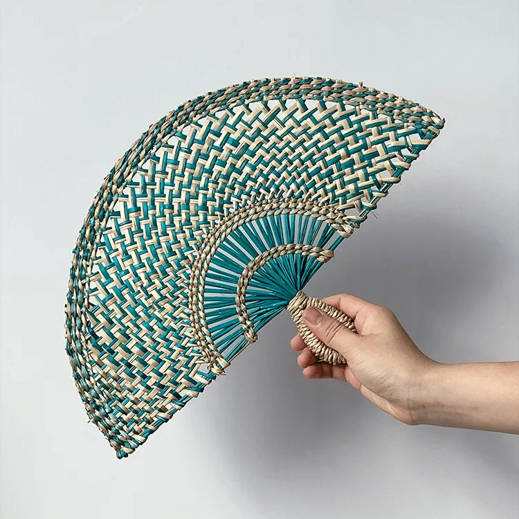 Green woven rattan fan wall decor with radiating ribs – shown in use