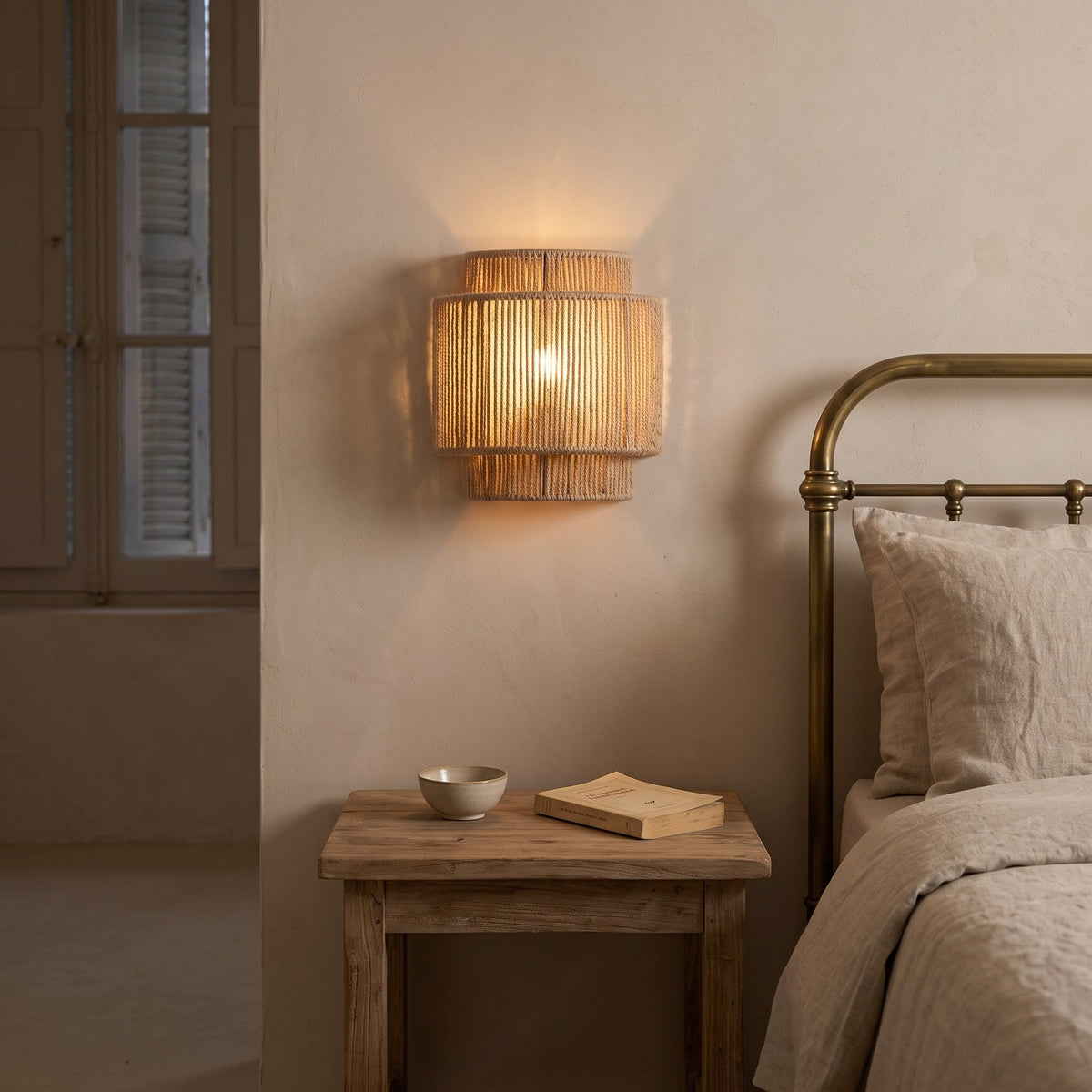 Two-tier braided hemp rope wall sconce casting light up and down – shown lit in a room setting