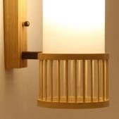 Handwoven cylindrical rattan wall sconce – close-up detail, lit (2)