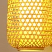 Slender handwoven rattan lantern wall sconce – close-up detail, lit