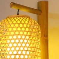 Slender handwoven rattan lantern wall sconce – shown lit (2)