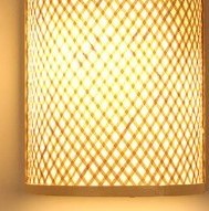 Framed rectangular handwoven rattan wall light – close-up detail, lit (2)