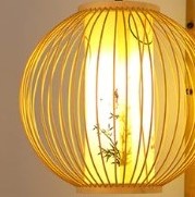 Round rattan wall sconce with an Asian-inspired woven pattern – close-up detail, lit